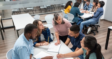 Faculty and students around desk